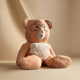 Plush teddy bear with glasses and a diaper on a beige background