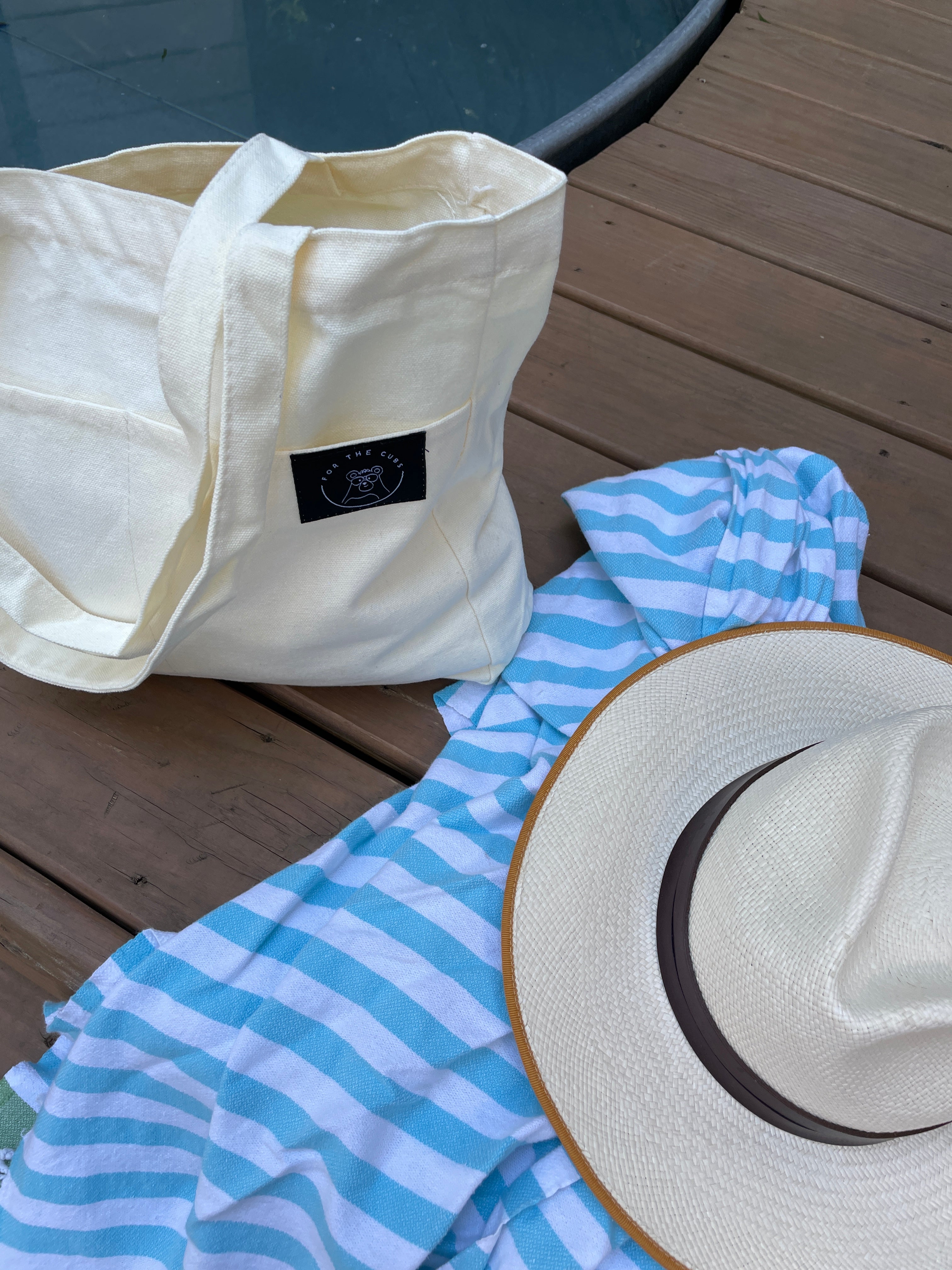 Everywhere tote bag by the pool set next to towel and straw hat