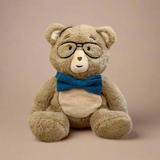 Teddy bear wearing glasses and a blue bow tie on a beige background