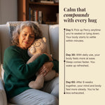 Woman hugging a Percy bear on a couch with text about the benefits of hugging after 30 days helping your mind and body feel more steady.