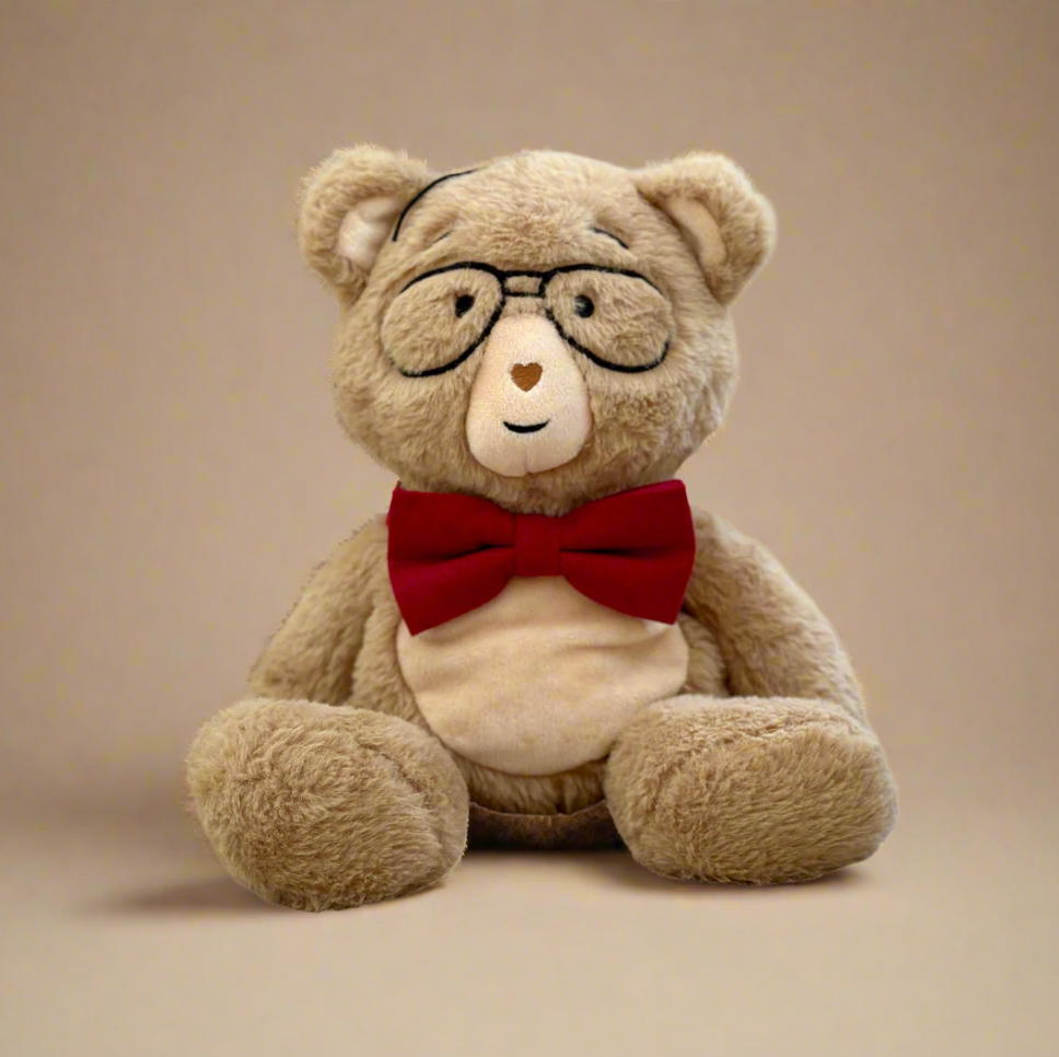 Teddy bear wearing glasses and a red bow tie on a beige background