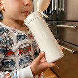 Young boy drinking from sand water bottle