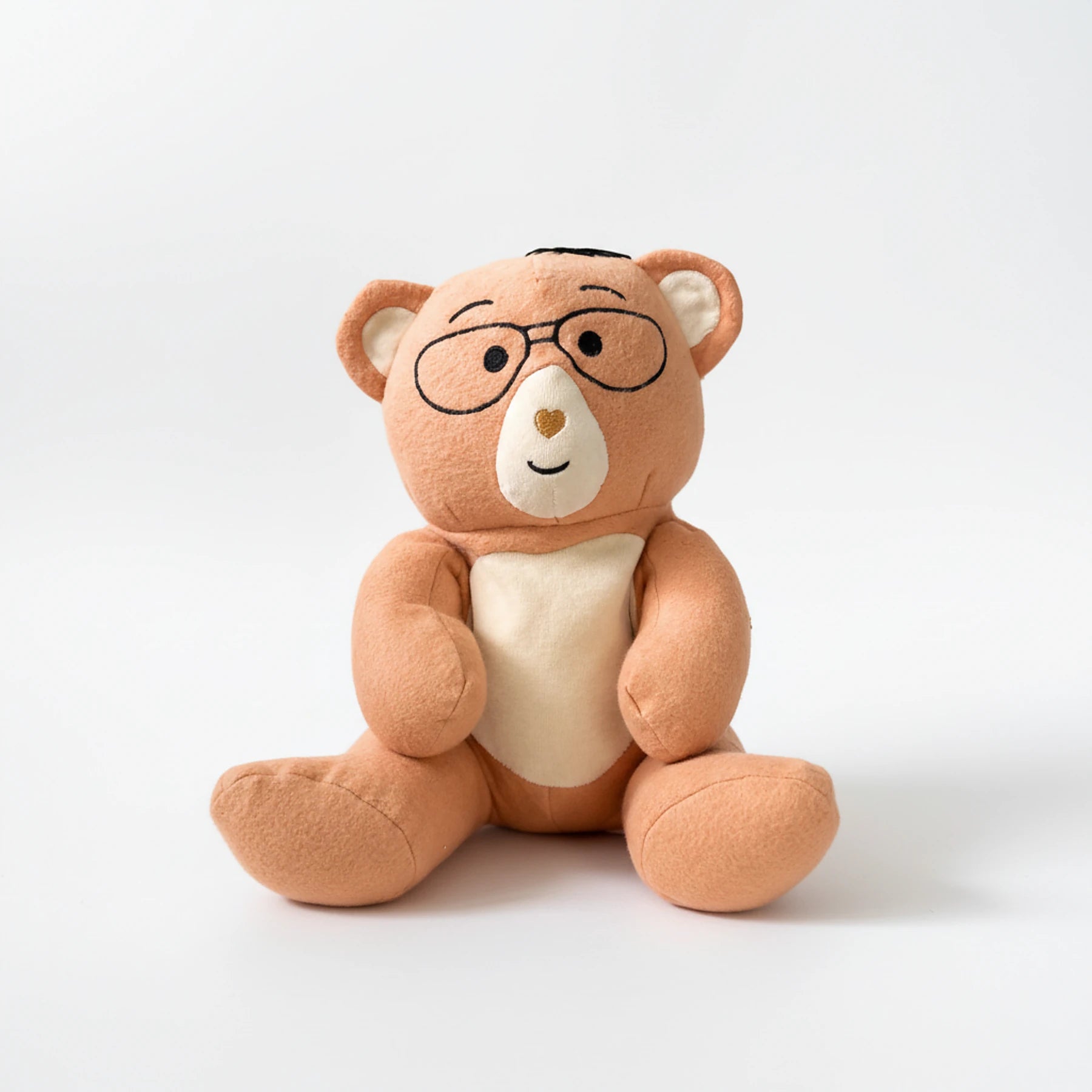 Plush Penny teddy bear with glasses on a white background