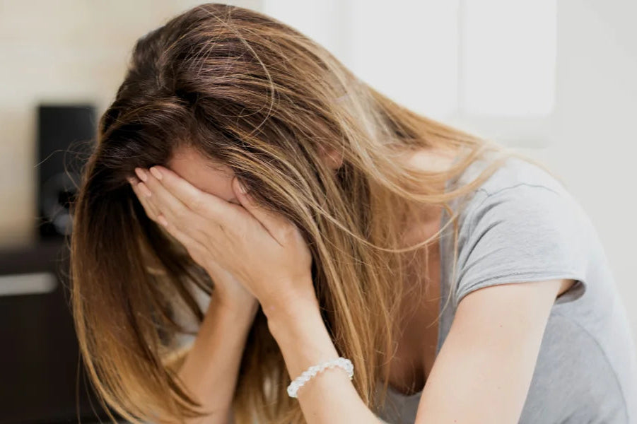 Woman with long hair covering her face in a room.
